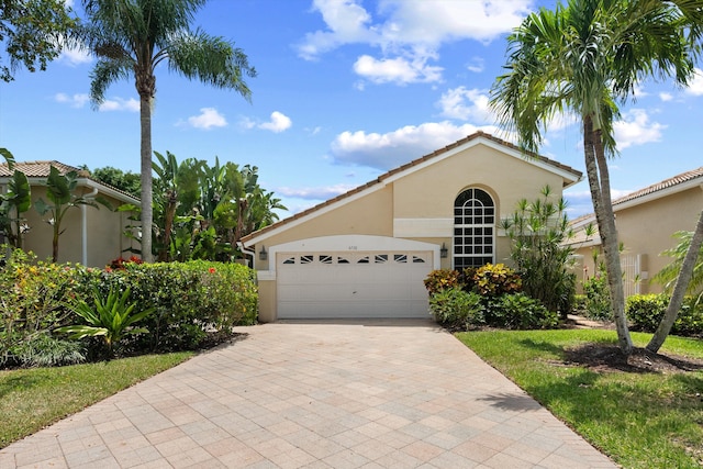 4738 Carlton Golf Dr, Lake Worth, FL 33449 - view of front of house featuring stucco siding, a tiled roof, an attached garage, and decorative driveway