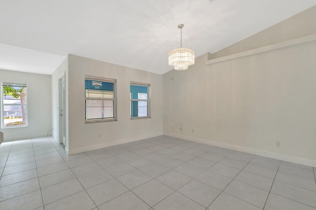 189 SE Floresta Dr, Port Saint Lucie, FL 34983 - unfurnished room featuring a chandelier, healthy amount of natural light, vaulted ceiling, light tile patterned floors, and baseboards