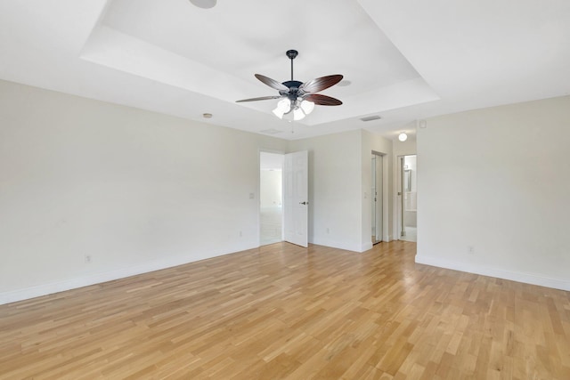 189 SE Floresta Dr, Port Saint Lucie, FL 34983 - spare room featuring a raised ceiling, a ceiling fan, light wood finished floors, and baseboards