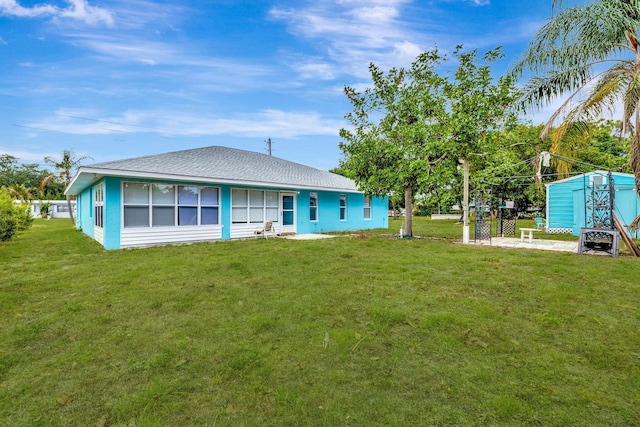 189 SE Floresta Dr, Port Saint Lucie, FL 34983 - back of house with a lawn and roof with shingles