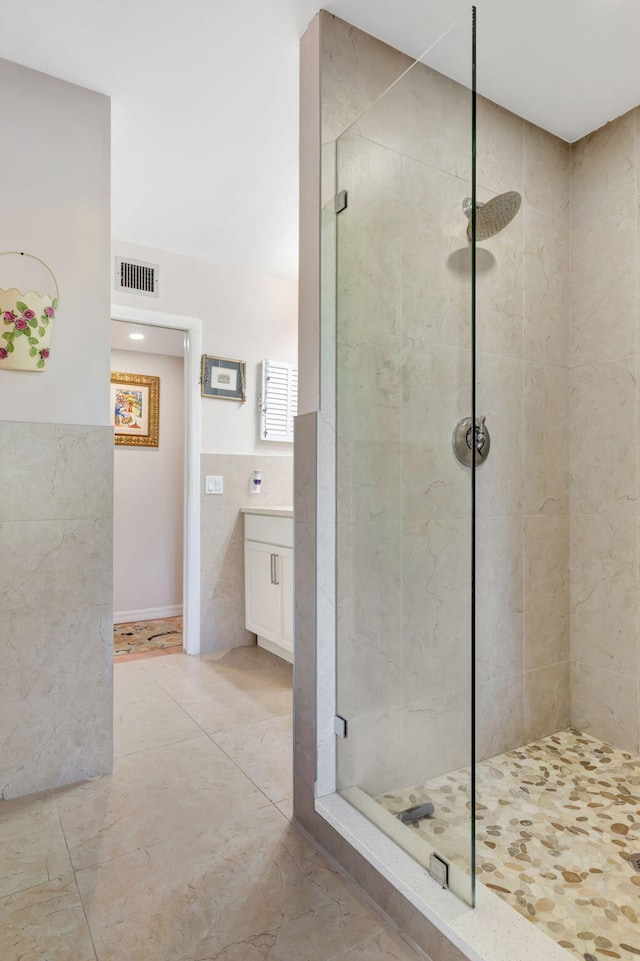 2971 SE Morningside Blvd, Port Saint Lucie, FL 34952 - bathroom with visible vents, tile patterned flooring, wainscoting, tile walls, and a shower stall