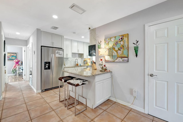 2971 SE Morningside Blvd, Port Saint Lucie, FL 34952 - kitchen featuring stainless steel refrigerator with ice dispenser, a peninsula, light tile patterned flooring, and visible vents