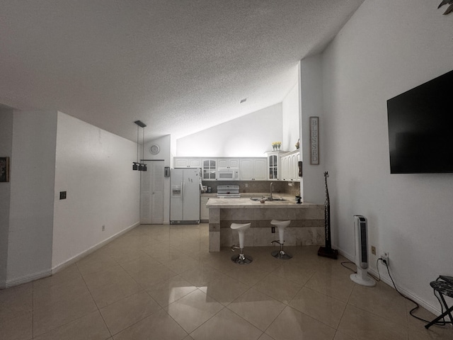 1101 Summit Place B Cir Unit B, West Palm Beach, FL 33415 - kitchen featuring white appliances, a peninsula, vaulted ceiling, glass insert cabinets, and a textured ceiling