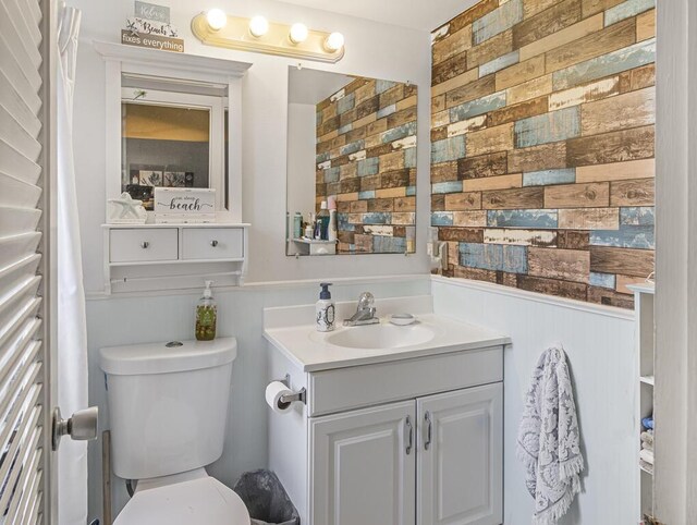 216 Sheffield I Unit 216, West Palm Beach, FL 33417 - bathroom with toilet, a wainscoted wall, vanity, and wood walls