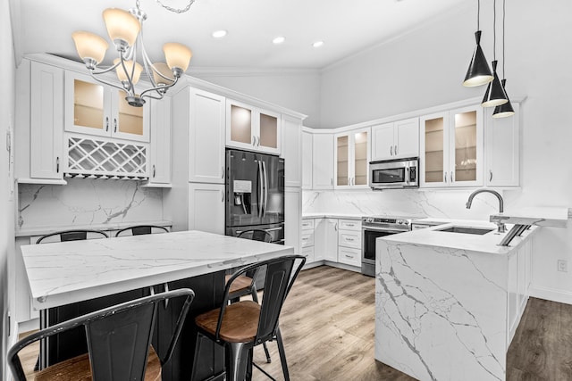 9676 Boca Gardens Pkwy Unit C, Boca Raton, FL 33496 - kitchen with appliances with stainless steel finishes, a peninsula, a chandelier, white cabinets, and backsplash