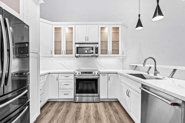 9676 Boca Gardens Pkwy Unit C, Boca Raton, FL 33496 - kitchen featuring appliances with stainless steel finishes, white cabinets, dark wood-style flooring, light stone countertops, and backsplash