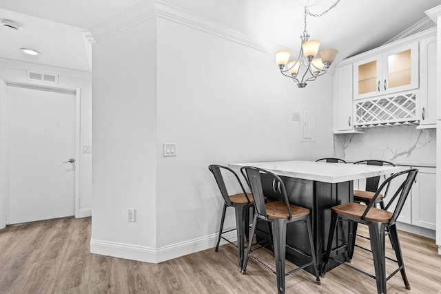 9676 Boca Gardens Pkwy Unit C, Boca Raton, FL 33496 - dining area featuring light wood-style floors, crown molding, and a chandelier