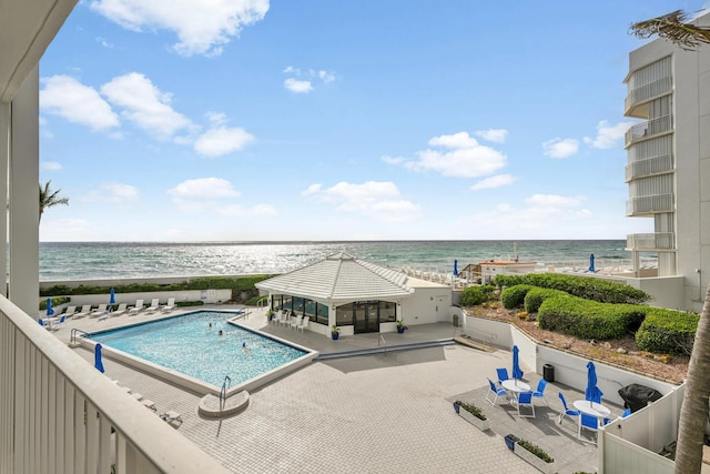 community pool with a water view and a patio area