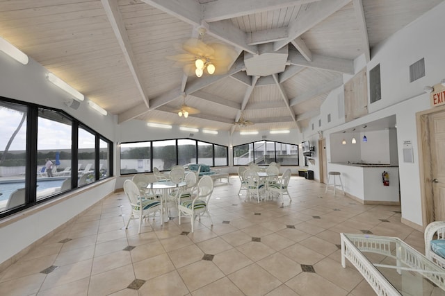 unfurnished sunroom featuring beamed ceiling, high vaulted ceiling, visible vents, and tile patterned flooring