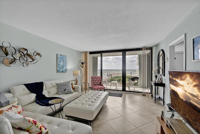 living area with a textured ceiling, floor to ceiling windows, and light tile patterned floors