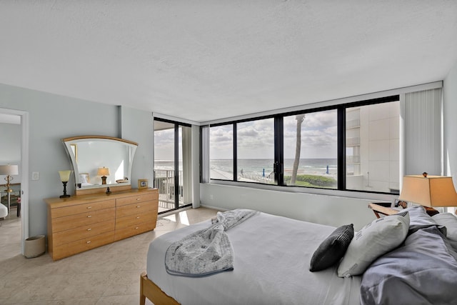 bedroom with light tile patterned floors, a textured ceiling, and access to exterior