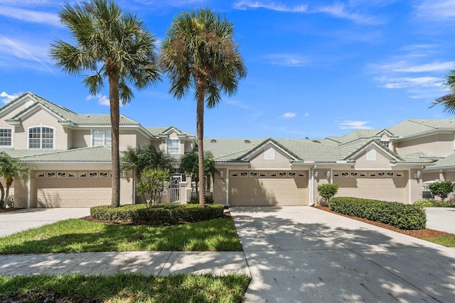view of property with stucco siding, concrete driveway, and a tiled roof