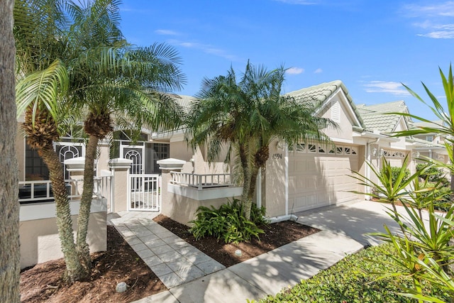 view of front of house featuring a fenced front yard, stucco siding, driveway, and a tile roof