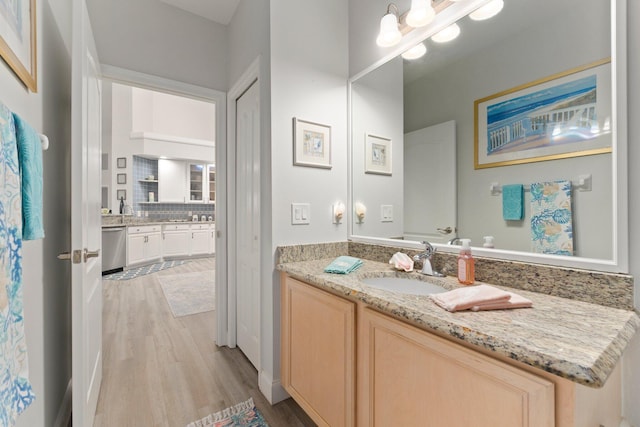 bathroom with tasteful backsplash, wood finished floors, and vanity