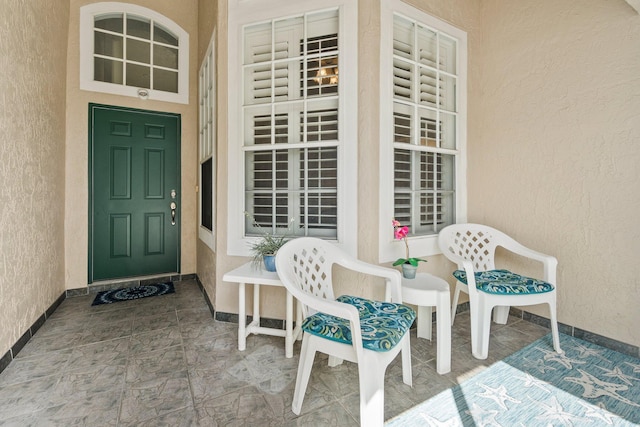 doorway to property featuring a porch and stucco siding