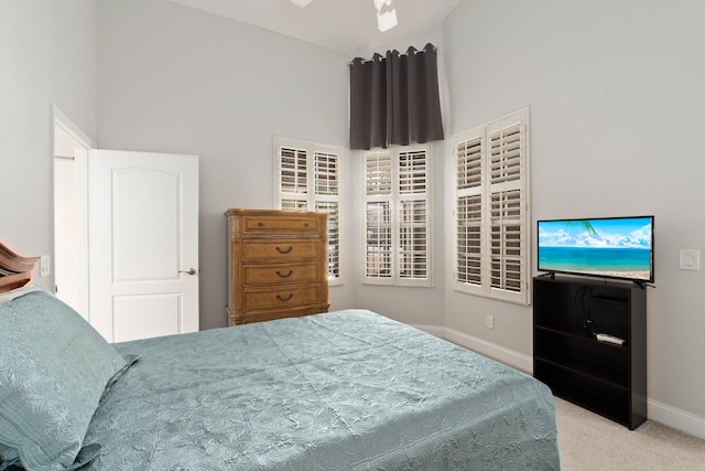 carpeted bedroom with baseboards and high vaulted ceiling