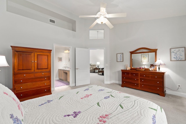 bedroom featuring ceiling fan, visible vents, baseboards, a high ceiling, and light carpet