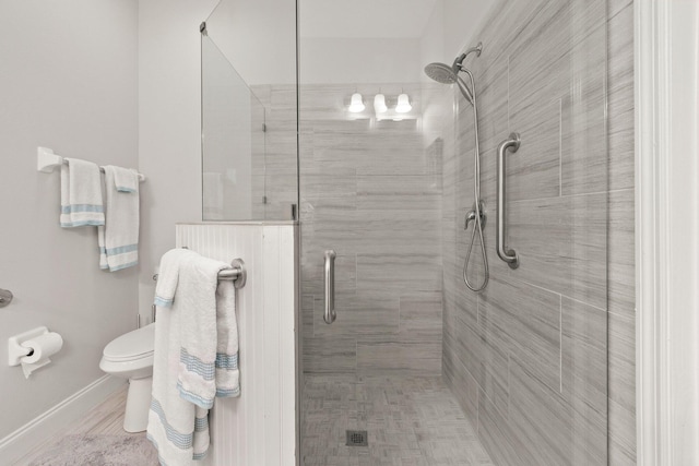 bathroom featuring a stall shower and toilet