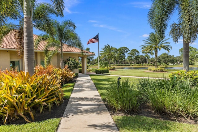 view of property's community featuring a lawn and a water view