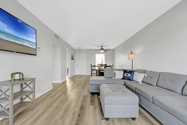 living room with a ceiling fan, light wood-style floors, and baseboards