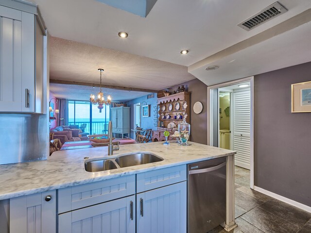 kitchen featuring visible vents, hanging light fixtures, dishwasher, a sink, and baseboards