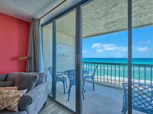 balcony with a water view and a beach view