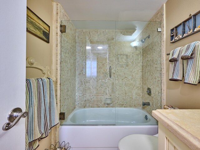 full bath with toilet, enclosed tub / shower combo, and vanity