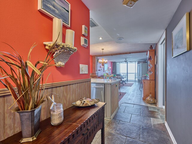 hallway with a chandelier, recessed lighting, stone tile flooring, and visible vents