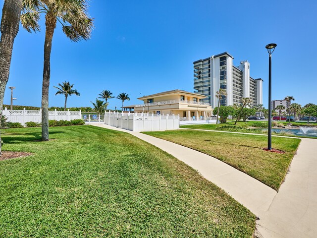 view of home's community featuring a lawn and fence