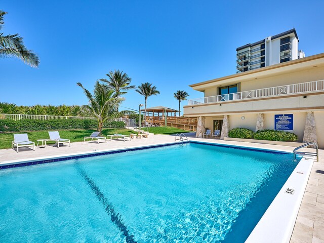 community pool with fence and a patio area