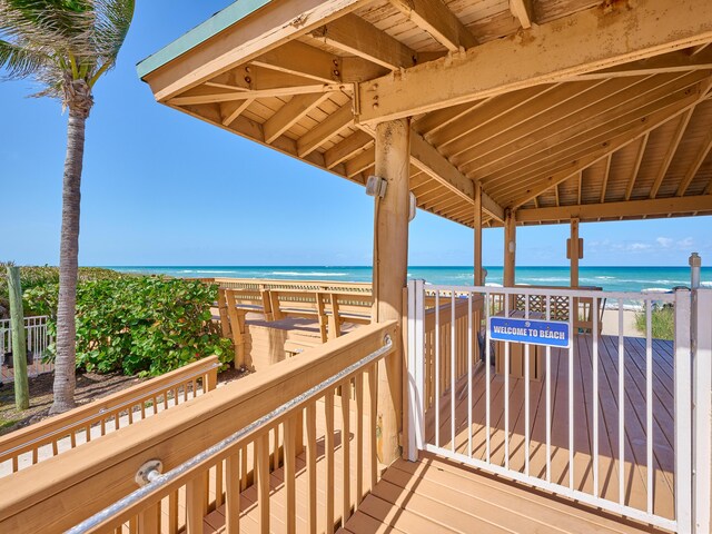 wooden deck with a beach view and a water view