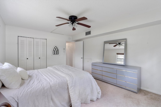 bedroom featuring a ceiling fan, visible vents, carpet, and a closet