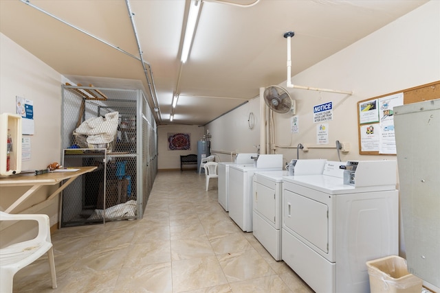 community laundry room featuring marble finish floor, water heater, and washing machine and dryer