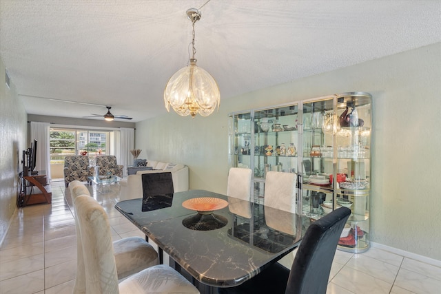 dining area with baseboards, ceiling fan with notable chandelier, a textured ceiling, and visible vents