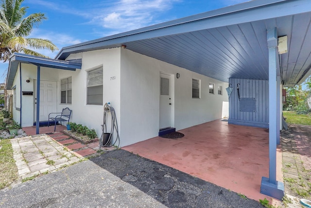 view of front facade featuring stucco siding and an attached carport