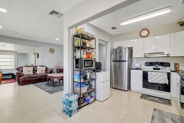 kitchen with appliances with stainless steel finishes, under cabinet range hood, white cabinetry, and visible vents
