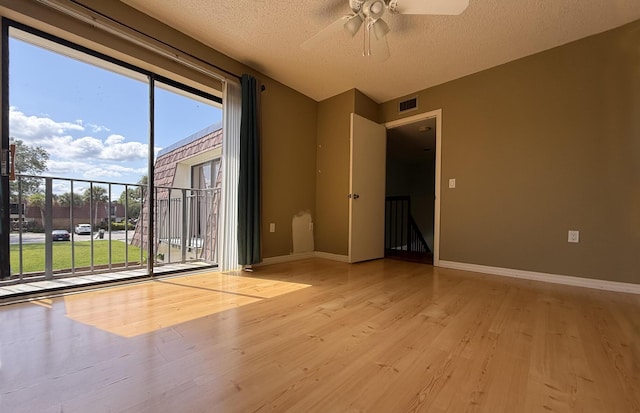 3031 SW Sunset Trace Cir, Palm City, FL 34990 - spare room with light wood-type flooring, a ceiling fan, healthy amount of natural light, baseboards, and a textured ceiling