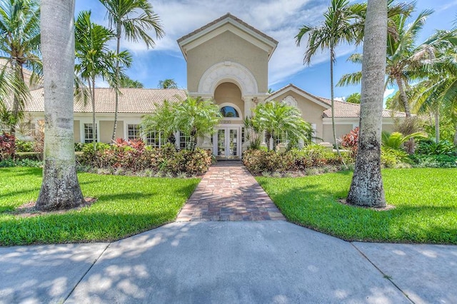 248 Village Blvd Unit 3203, Tequesta, FL 33469 - view of front facade featuring french doors, stucco siding, a tiled roof, and a front lawn