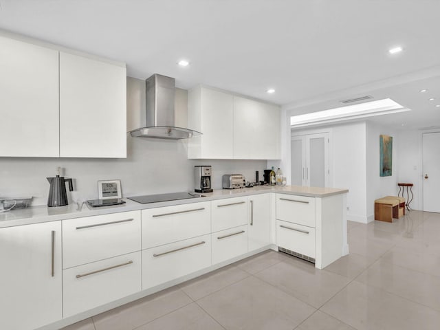 3300 S Ocean Blvd Unit 108S, Palm Beach, FL 33480 - kitchen featuring modern cabinets, light tile patterned floors, a peninsula, black electric stovetop, and wall chimney exhaust hood
