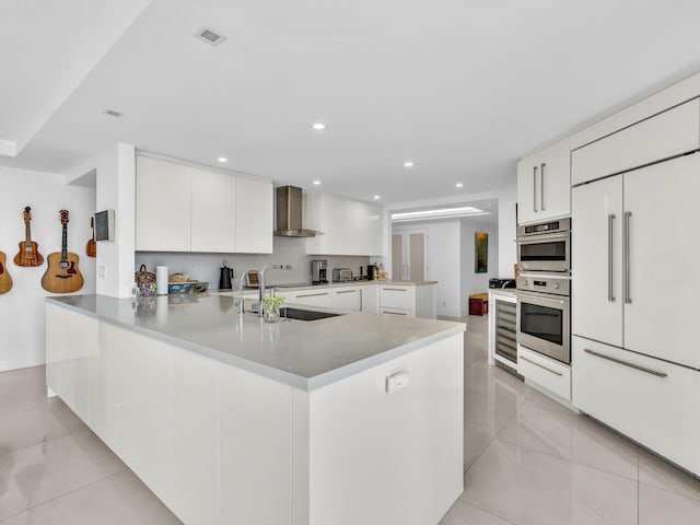 3300 S Ocean Blvd Unit 108S, Palm Beach, FL 33480 - kitchen featuring a peninsula, modern cabinets, wall chimney exhaust hood, built in refrigerator, and a sink