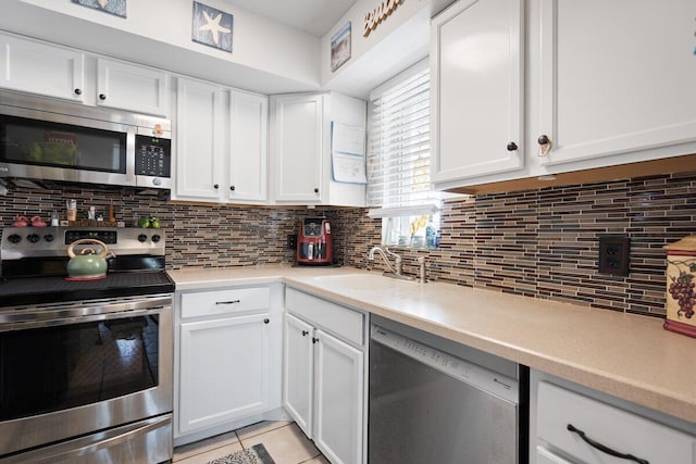 1627 SE Green Acres Cir Unit Z-203, Port Saint Lucie, FL 34952 - kitchen with light countertops, white cabinets, and stainless steel appliances