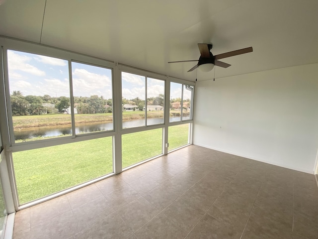unfurnished sunroom with a water view and ceiling fan