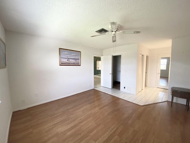 1120 Mahogany Way Unit 203, Delray Beach, FL 33445 - unfurnished bedroom featuring wood finished floors, a ceiling fan, a textured ceiling, baseboards, and a closet