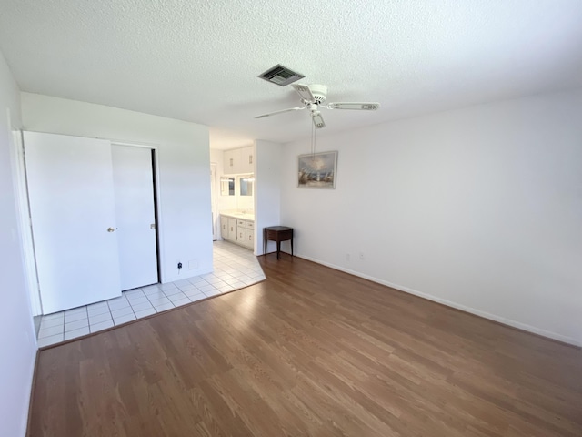 1120 Mahogany Way Unit 203, Delray Beach, FL 33445 - unfurnished bedroom with wood finished floors, baseboards, a textured ceiling, a ceiling fan, and a closet