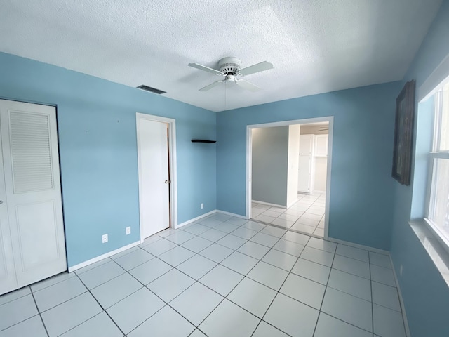1120 Mahogany Way Unit 203, Delray Beach, FL 33445 - unfurnished bedroom featuring a textured ceiling, baseboards, ceiling fan, and light tile patterned flooring