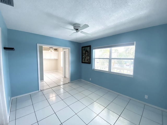 1120 Mahogany Way Unit 203, Delray Beach, FL 33445 - empty room with ceiling fan, a textured ceiling, light tile patterned floors, and baseboards