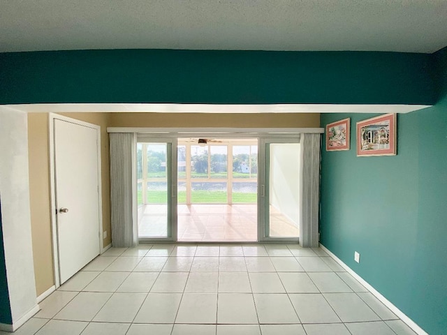 1120 Mahogany Way Unit 203, Delray Beach, FL 33445 - empty room featuring baseboards, light tile patterned flooring, and a textured ceiling