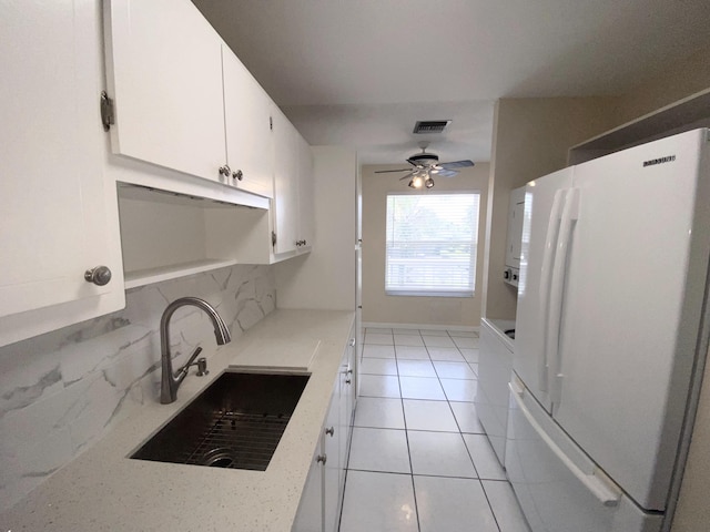 1120 Mahogany Way Unit 203, Delray Beach, FL 33445 - kitchen featuring freestanding refrigerator, a sink, decorative backsplash, white cabinetry, and ceiling fan