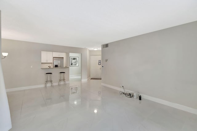 unfurnished room featuring light tile patterned floors, baseboards, and visible vents