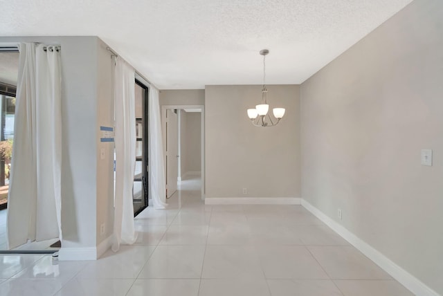 interior space featuring a textured ceiling, a chandelier, and baseboards